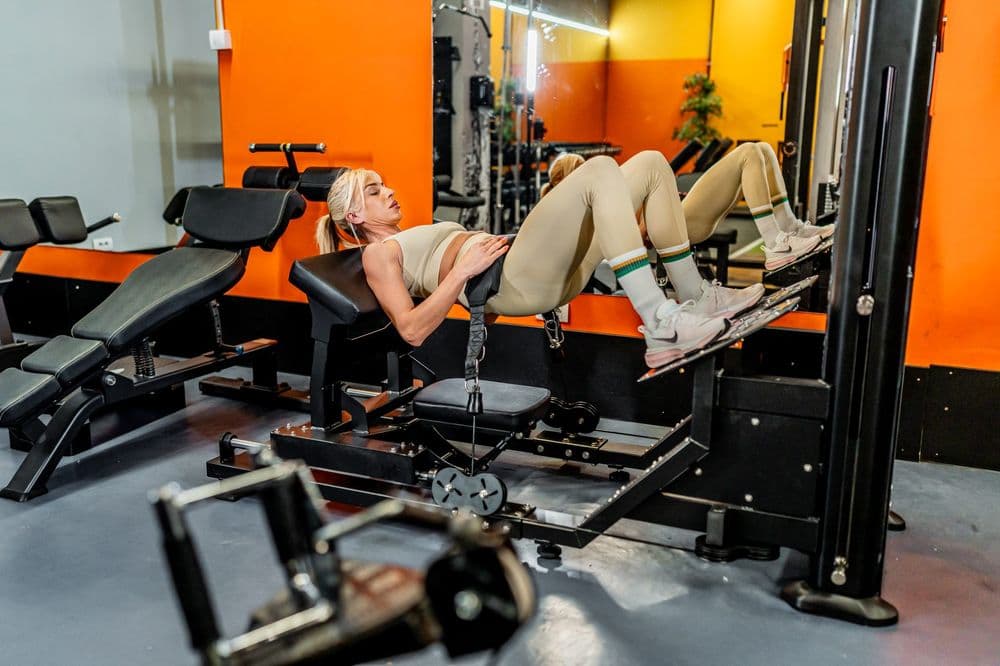 Članica radi hip thrust na mašini za gluteus u teretani Aura u Nišu